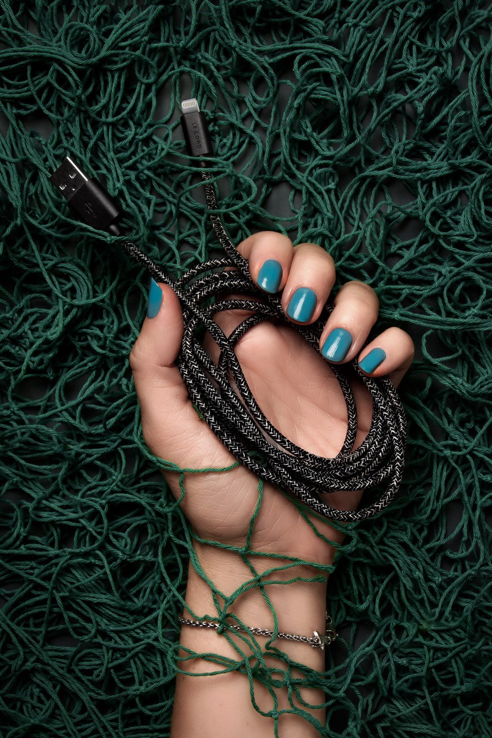 Schwarzes Apple MFi Lightning-Kabel 2 m aus recycelten Fischernetzen in der Hand