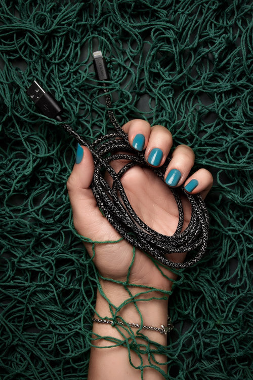 Schwarzes Apple MFi Lightning-Kabel 2 m aus recycelten Fischernetzen in der Hand